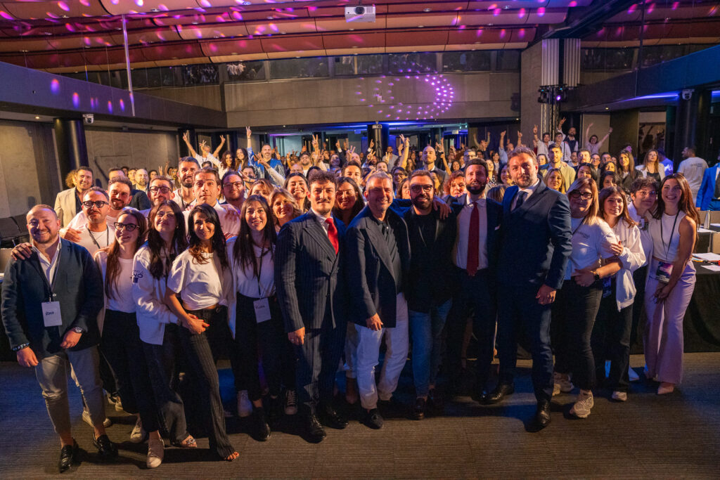 Relatori sul palco e pubblico durante l’evento formativo Destinati a essere i Numeri Uno di Revolution Business School